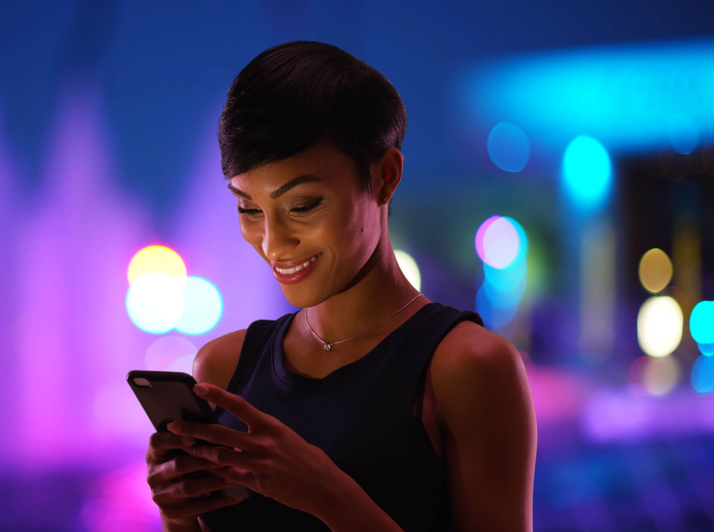 Young woman texting at night