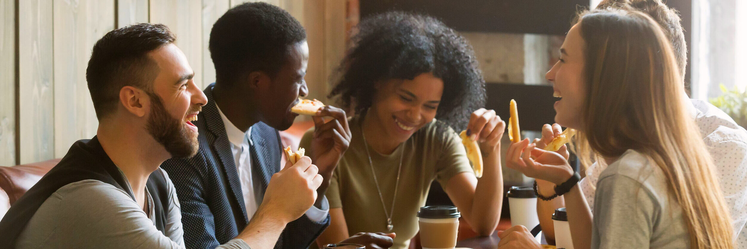 Friends laughing and eating pizza